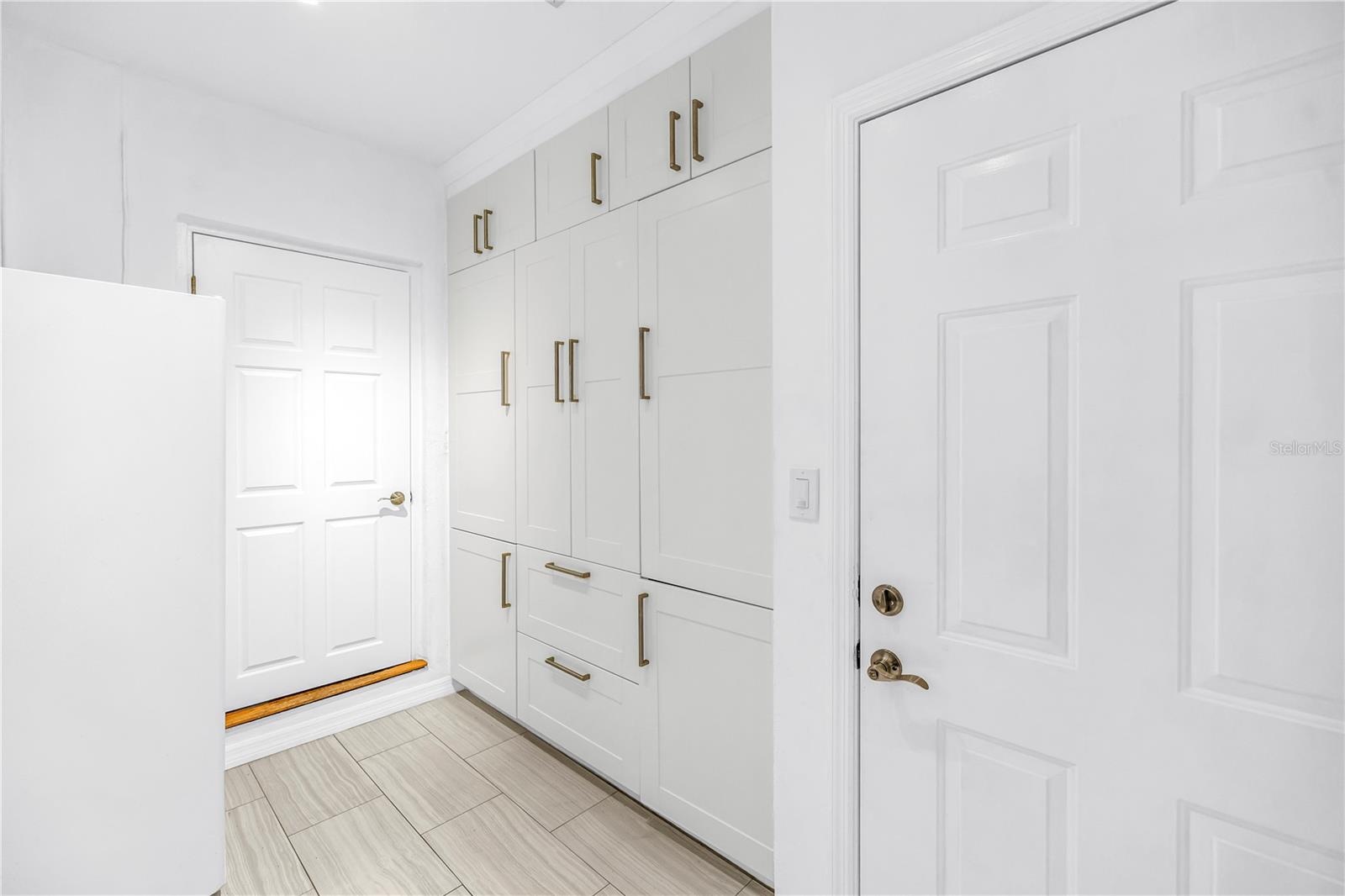 Custom cabinetry featuring ample storage solutions for laundry detergents, bulk household inventory, and utility organization.