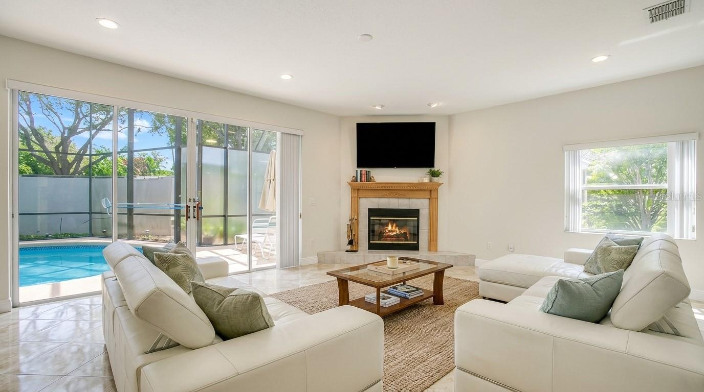 Stunning living room with an open view overlooking the backyard and private pool.