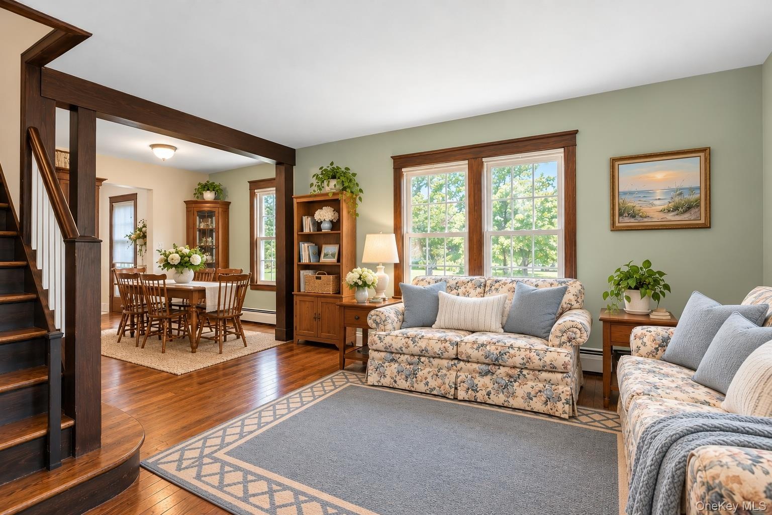 Hardwood flooring, natural wood trim, and a prominent staircase with a curved lower tread