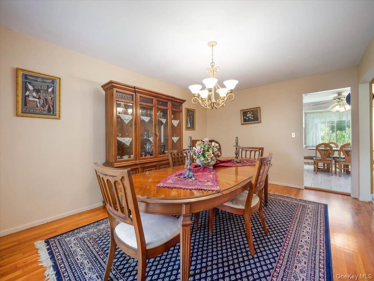 Dining area featuring wood-finish flooring, a multi-arm brass chandelier, and built-in wood cabinetry