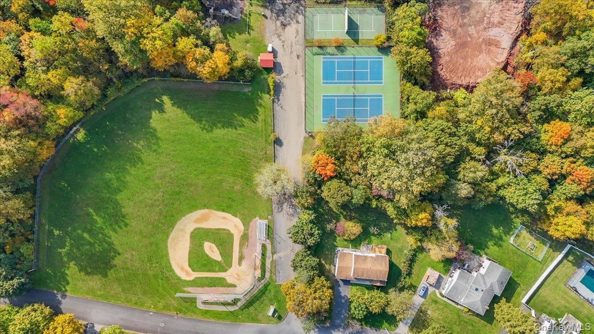 Aerial perspective featuring two dedicated tennis courts and a baseball field with a grass infield