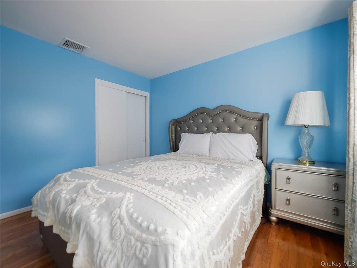 Bedroom featuring wood-finish flooring and a sliding door closet