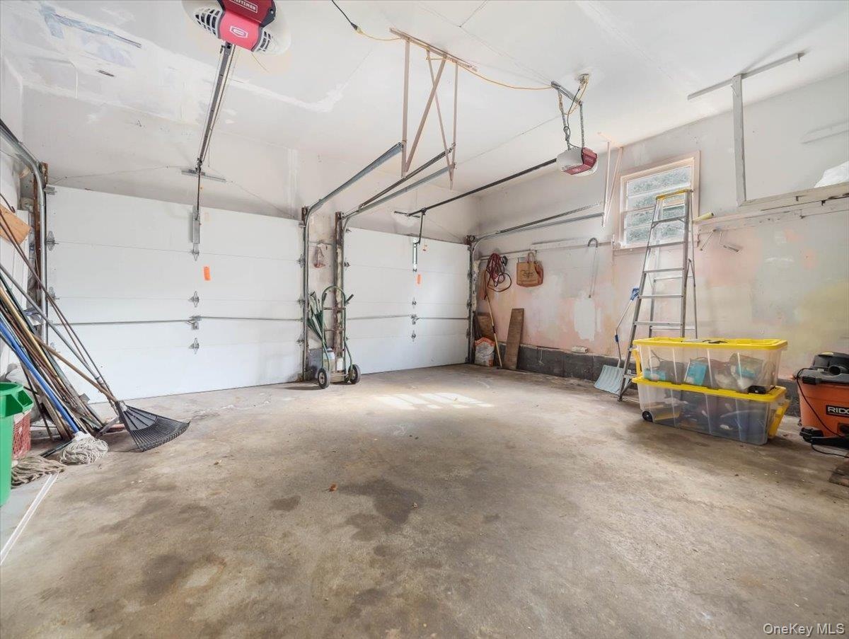 Two-car garage featuring dual overhead doors, concrete flooring, and a single window