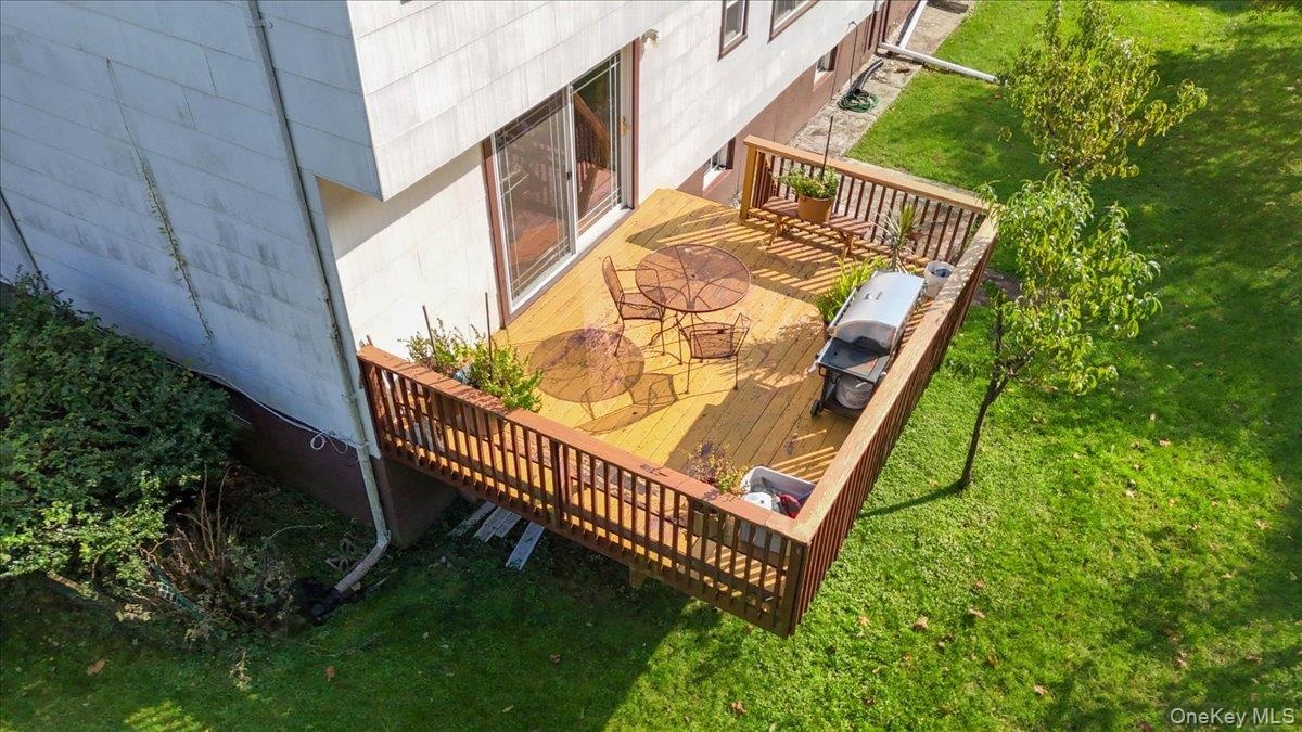 Elevated wood deck featuring vertical balustrade railings and sliding glass door access
