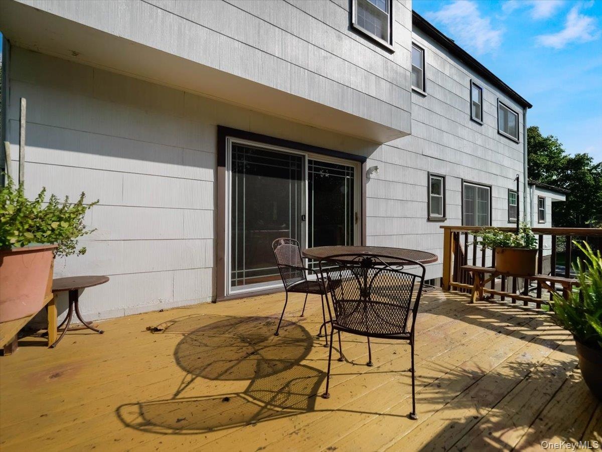 Rear wood deck featuring an attached wood railing and a sliding glass door