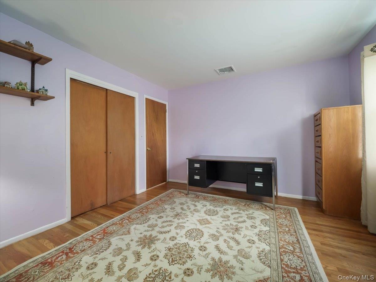 Hardwood flooring, wood-finish sliding closet doors, and wall-mounted shelving