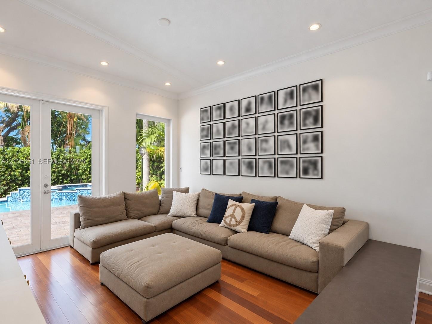 Interior space featuring wood-finish flooring, recessed lighting, crown molding, double glass-paneled doors, and floor-to-ceiling windows