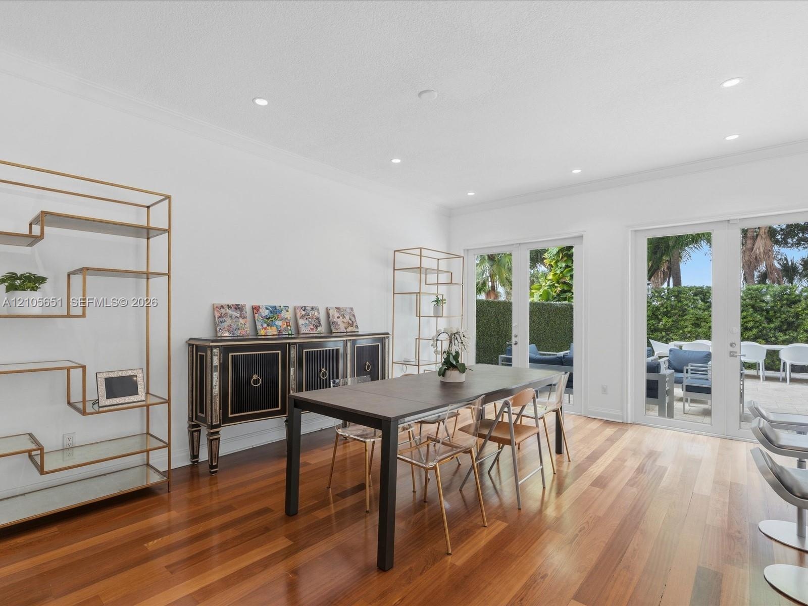 Wood-finish flooring, recessed lighting, crown molding, and dual glass-panel doors