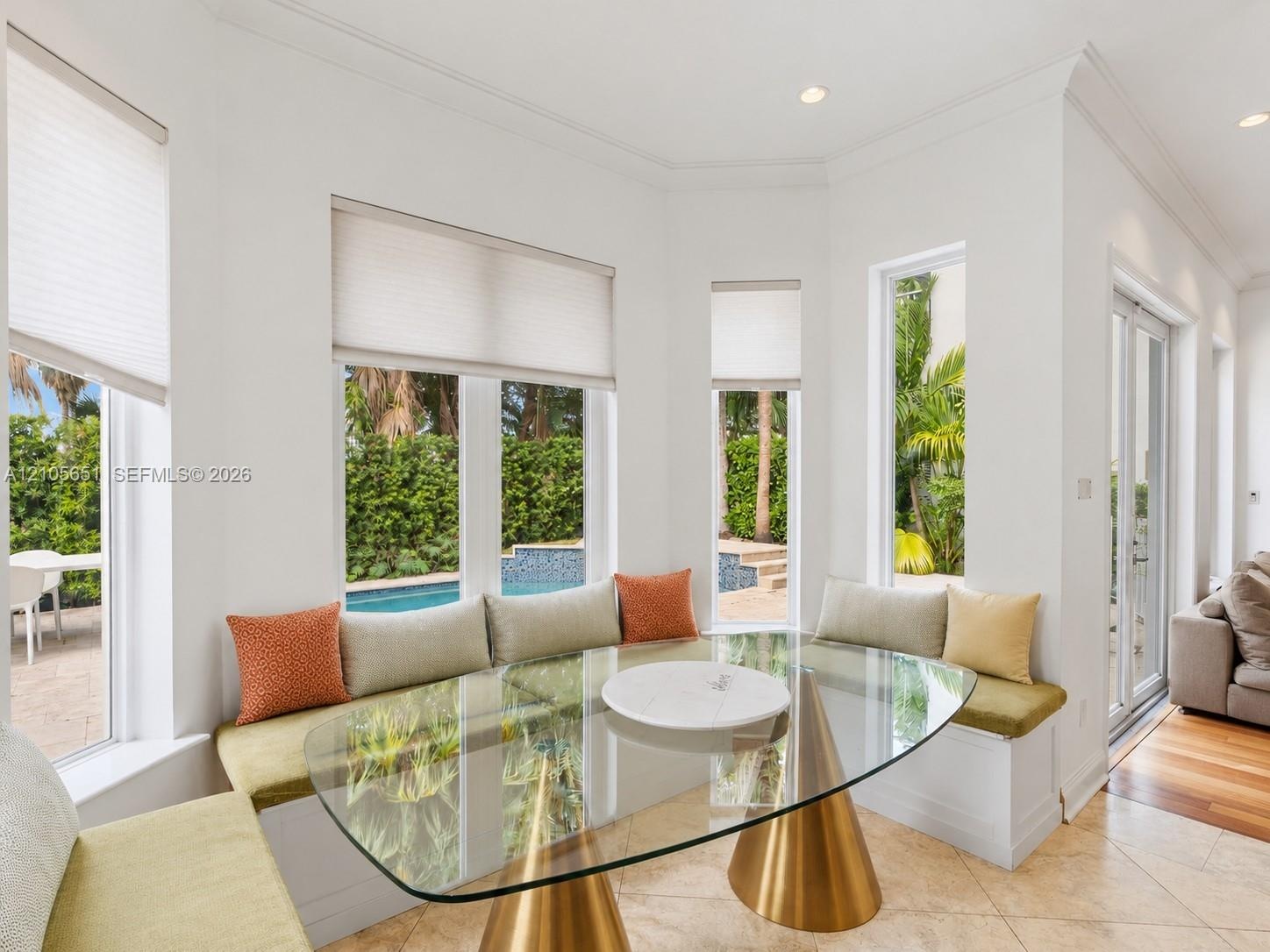 Bay window featuring built-in bench seating, recessed lighting, crown molding, and large-format tile flooring
