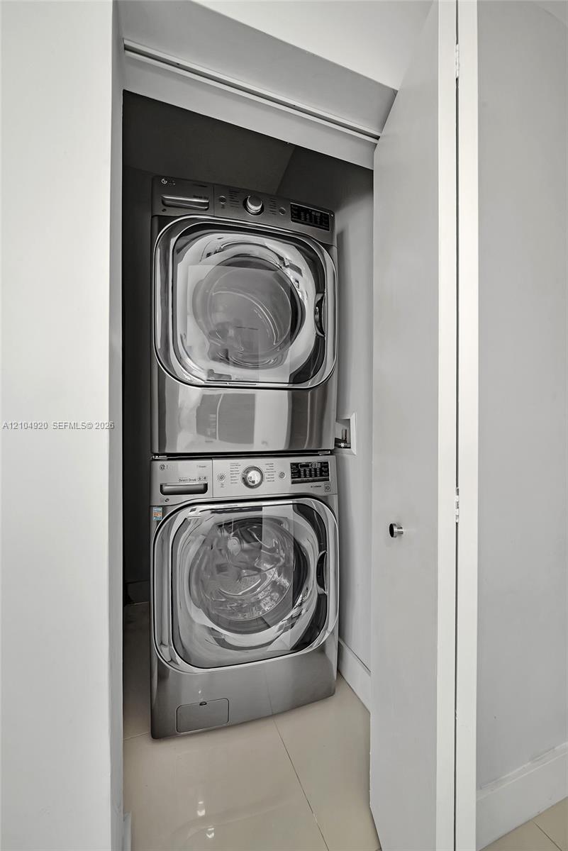 Closet housing a stackable stainless steel washer and dryer unit
