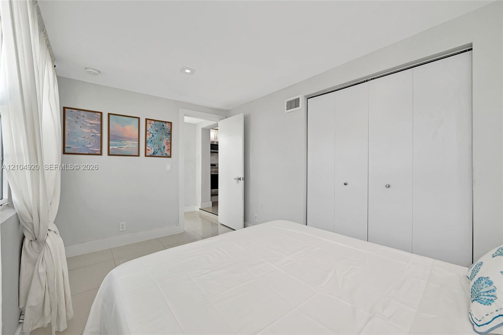 Interior room featuring large-format tile flooring, recessed lighting, and a double-door closet with polished hardware