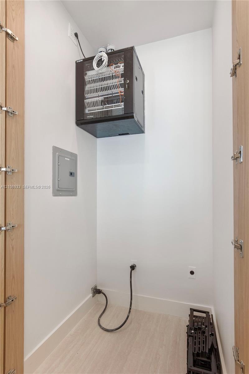 Wall-mounted network enclosure, flush-mounted electrical service panel, and neutral wood-finish flooring