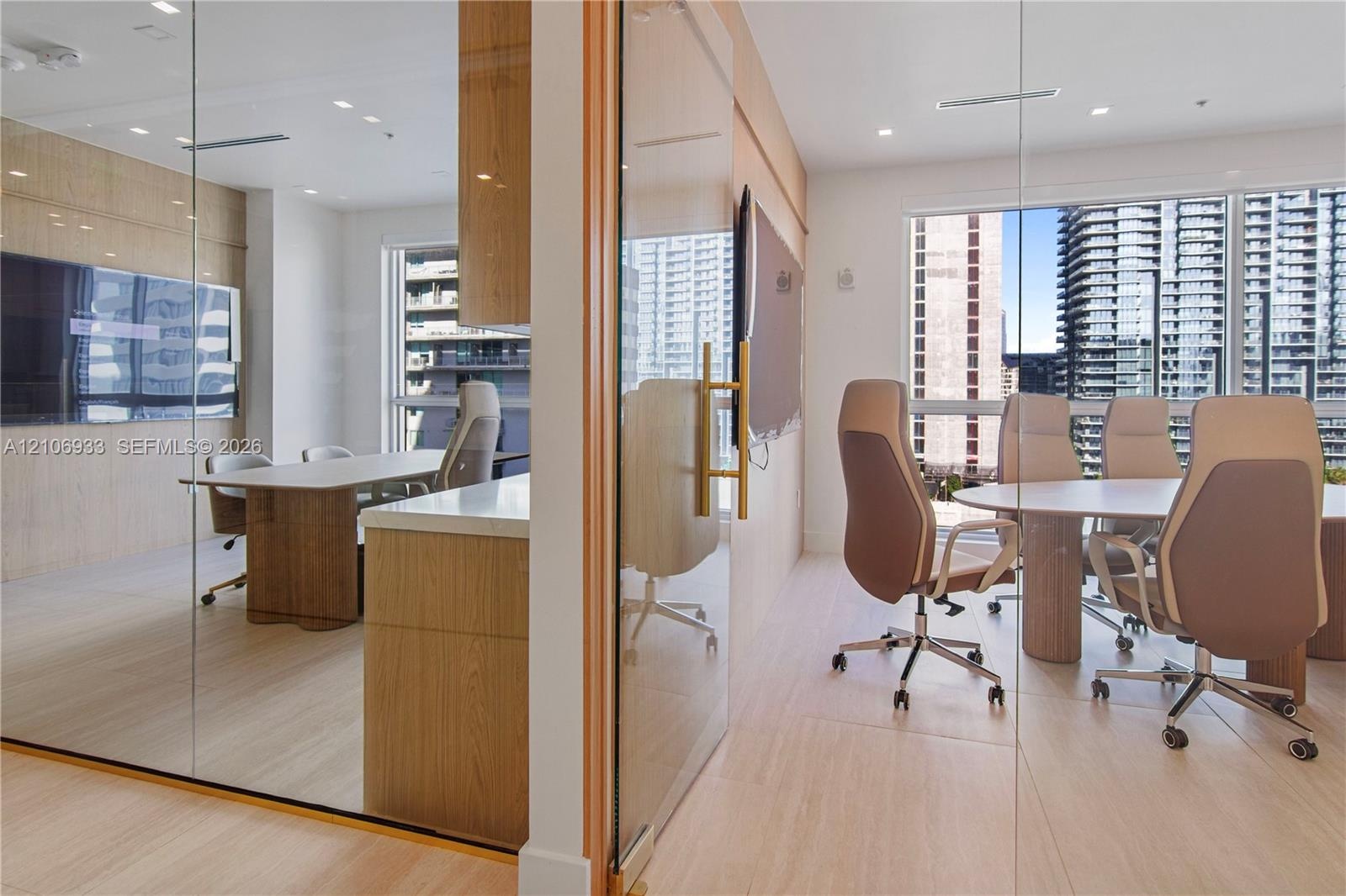 Floor-to-ceiling glass wall partitions, wood-finish flooring, custom wood-veneer cabinetry, quartz-surface countertops, and recessed ceiling lighting