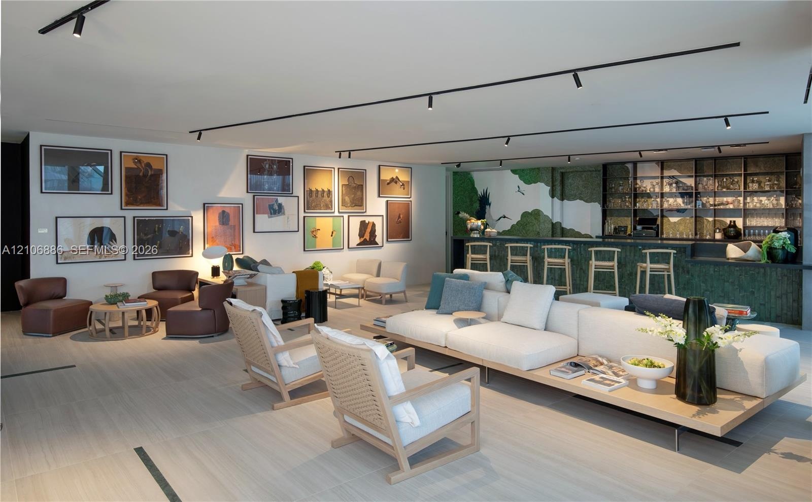 Open floor plan featuring wood-finish flooring, built-in wet bar with glass shelving, and track lighting system