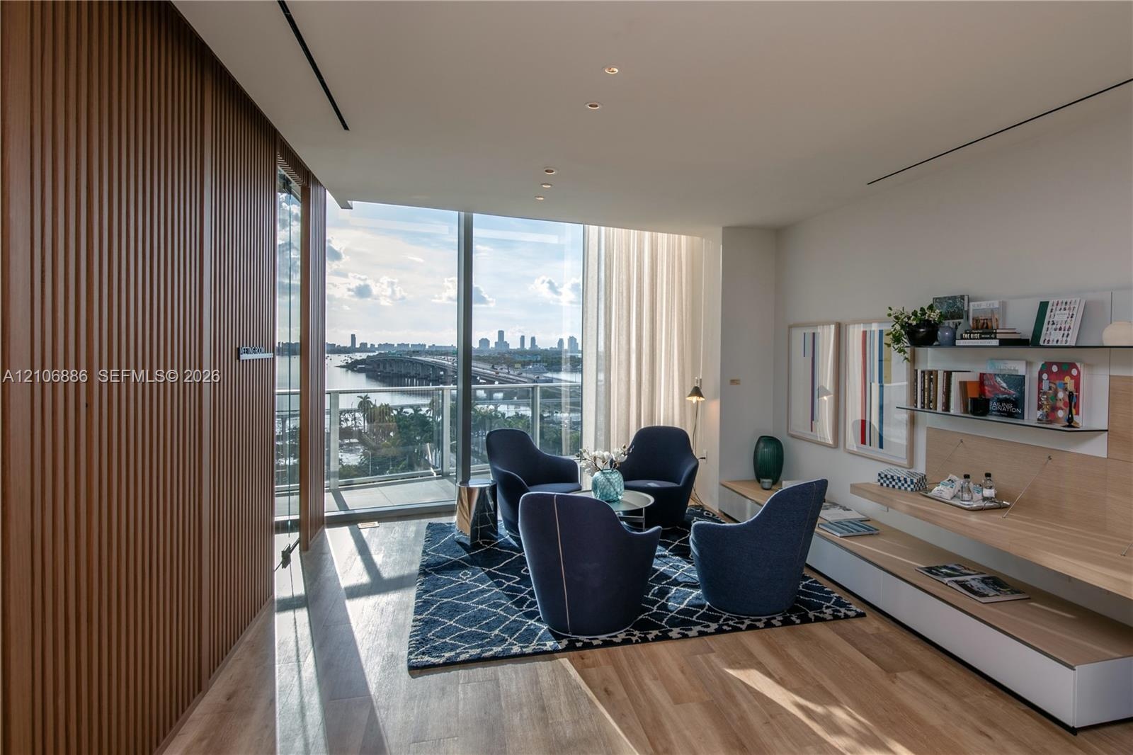 Floor-to-ceiling windows, integrated wood-slat wall paneling, built-in wall shelving with light wood finish, recessed ceiling lighting, and wood-finis