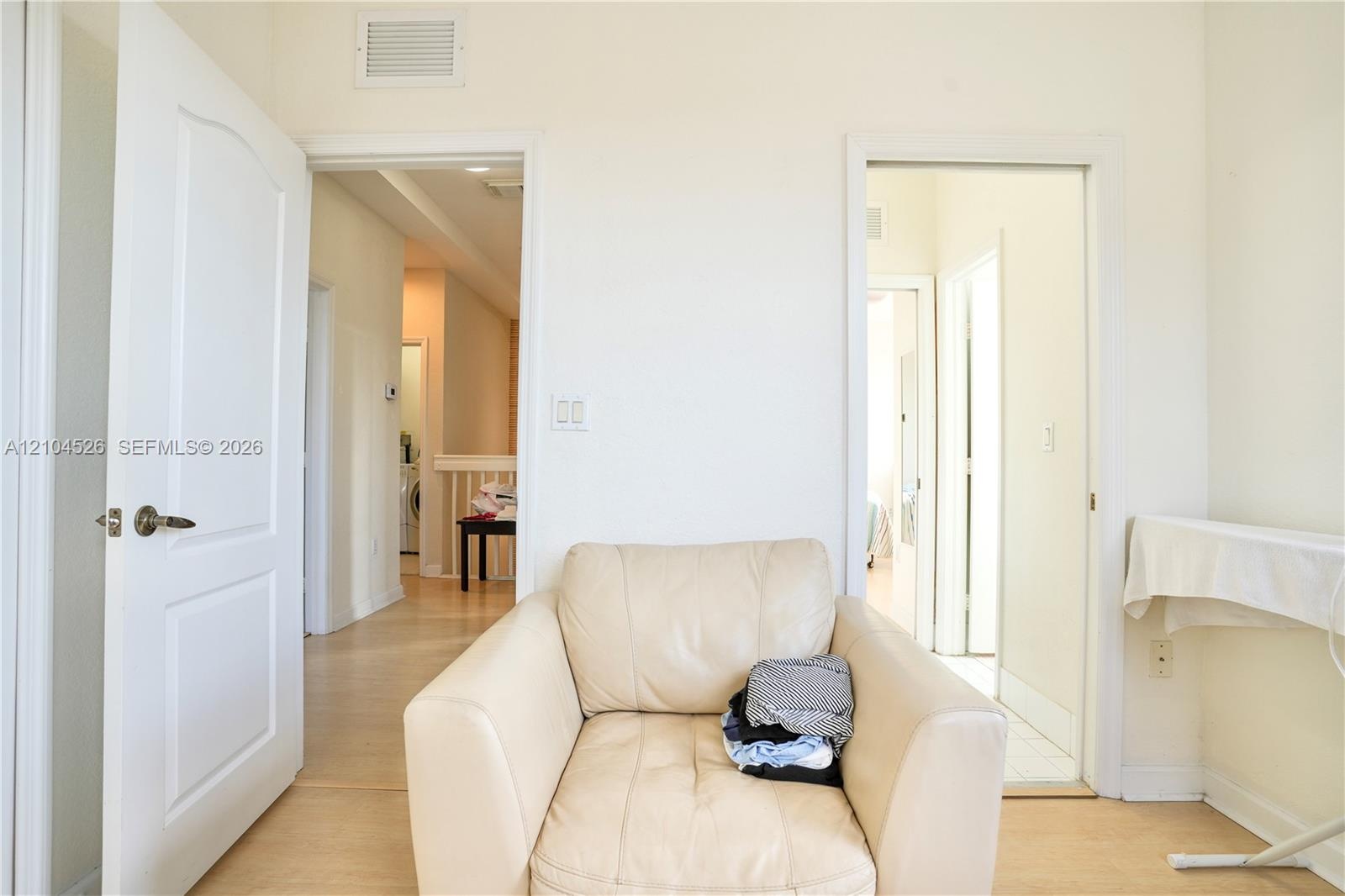 Interior space featuring wood-finish flooring, two sets of paneled doors, and light-toned wall finishes