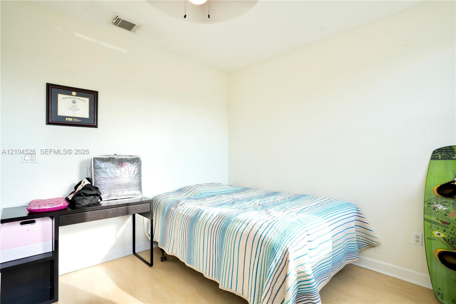 Neutral wall palette with wood-finish flooring and a ceiling-mounted light fixture