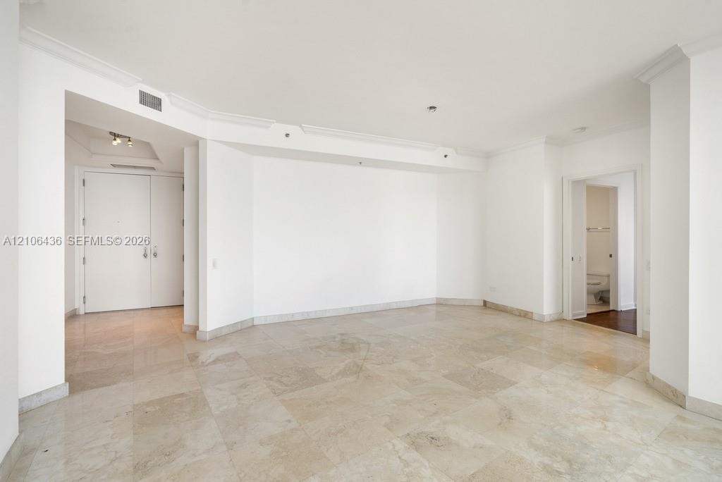 Open interior featuring stone tile flooring, crown molding, and recessed lighting