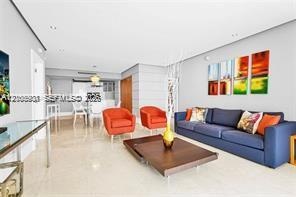 Open-concept interior featuring light-toned stone-finish flooring, recessed lighting, and smooth-finish walls