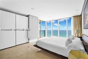 Floor-to-ceiling windows, built-in floor-to-ceiling cabinetry, recessed lighting, and stone flooring
