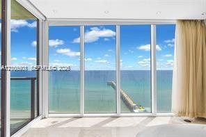 Floor-to-ceiling glass panel walls, recessed ceiling lighting, and polished stone flooring