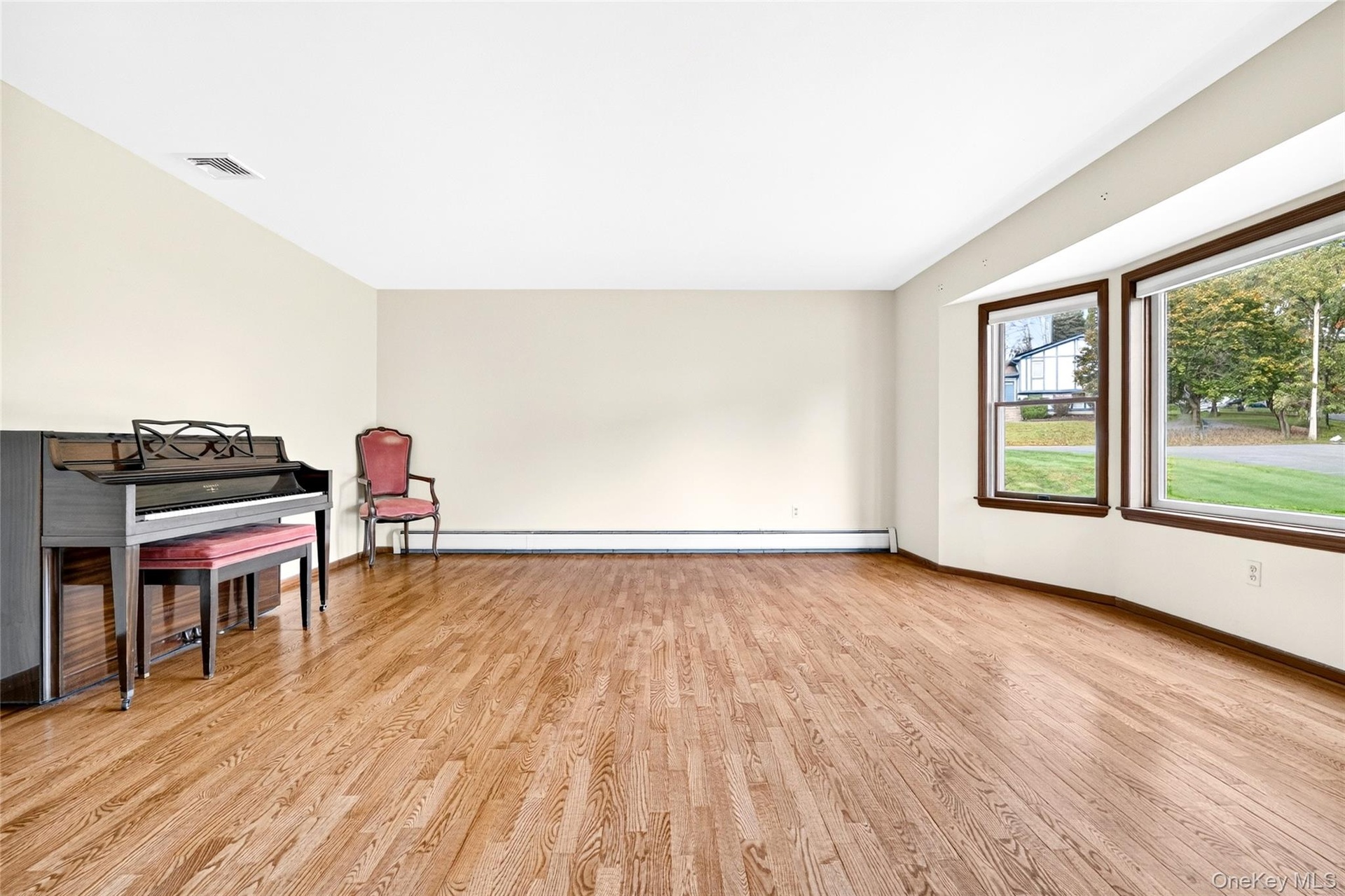 Spacious interior featuring wood-finish flooring, neutral wall tones, and a large bay window configuration