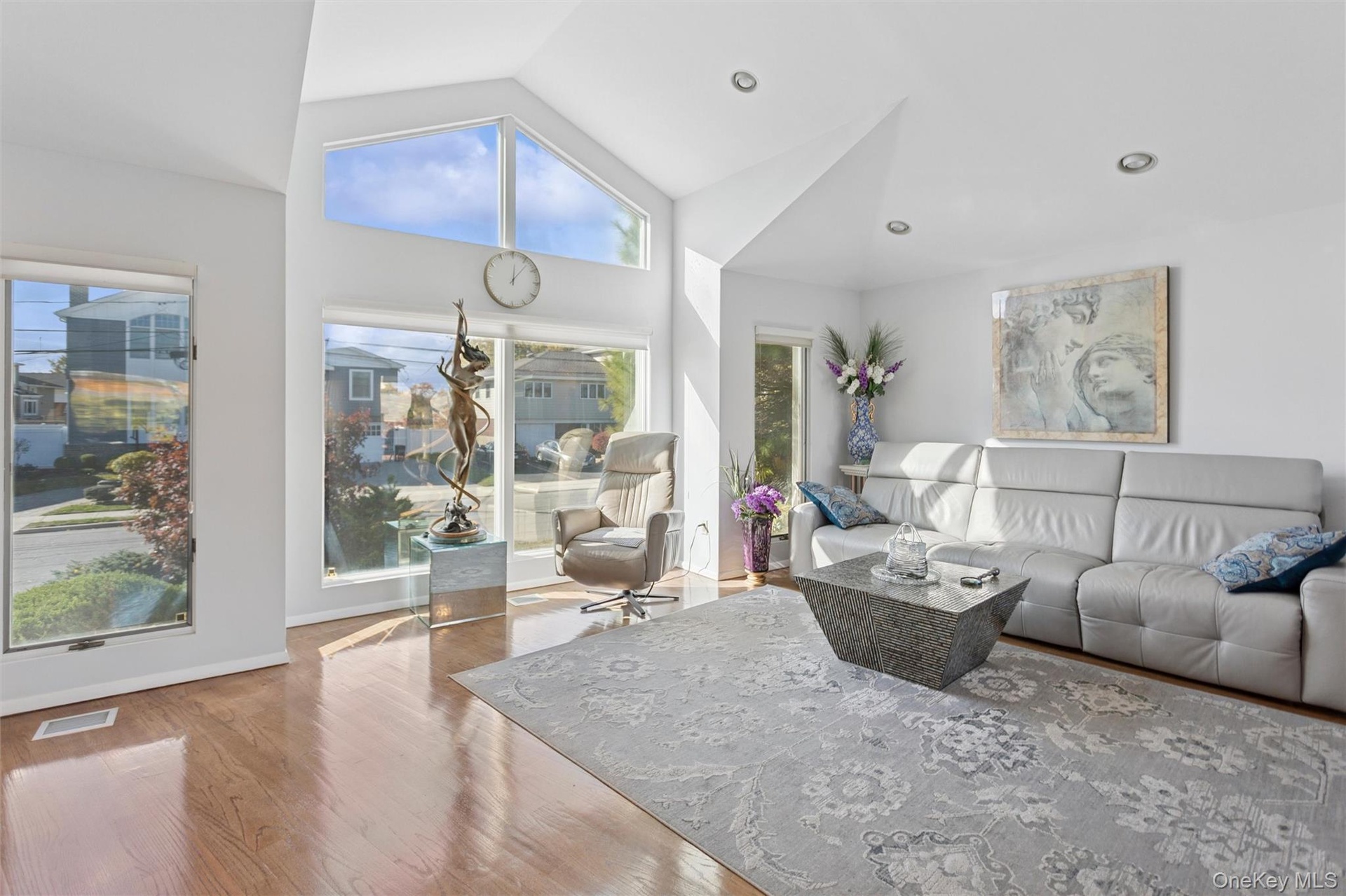 Living room featuring wood finished floors, high vaulted ceiling, and recessed lighting
