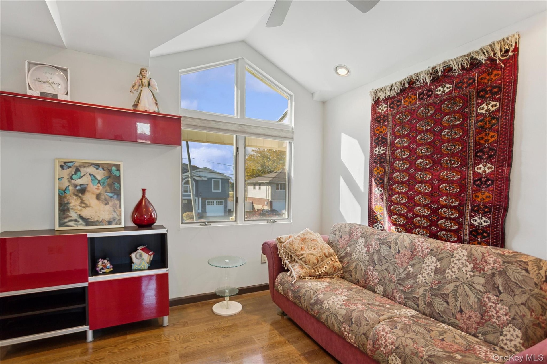 Living area featuring vaulted ceiling, wood finished floors, and a ceiling fan