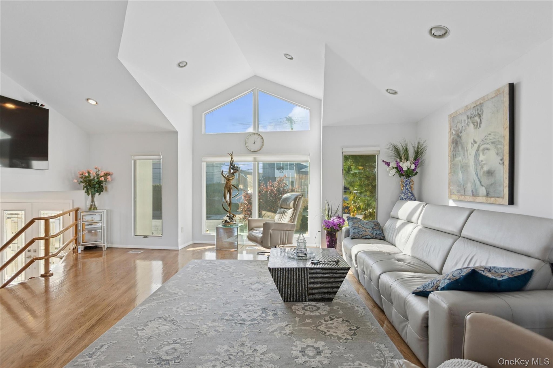 Living room featuring light wood finished floors, recessed lighting, and high vaulted ceiling