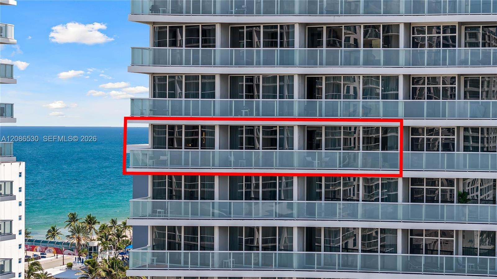 High-rise balcony featuring floor-to-ceiling glass doors and a glass panel railing