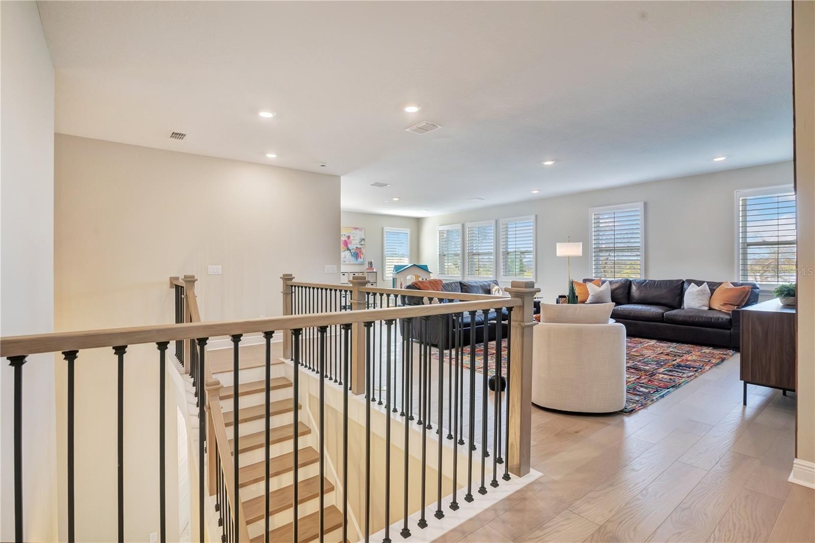 Open upstairs landing with upgraded stair railings leads into a spacious loft.