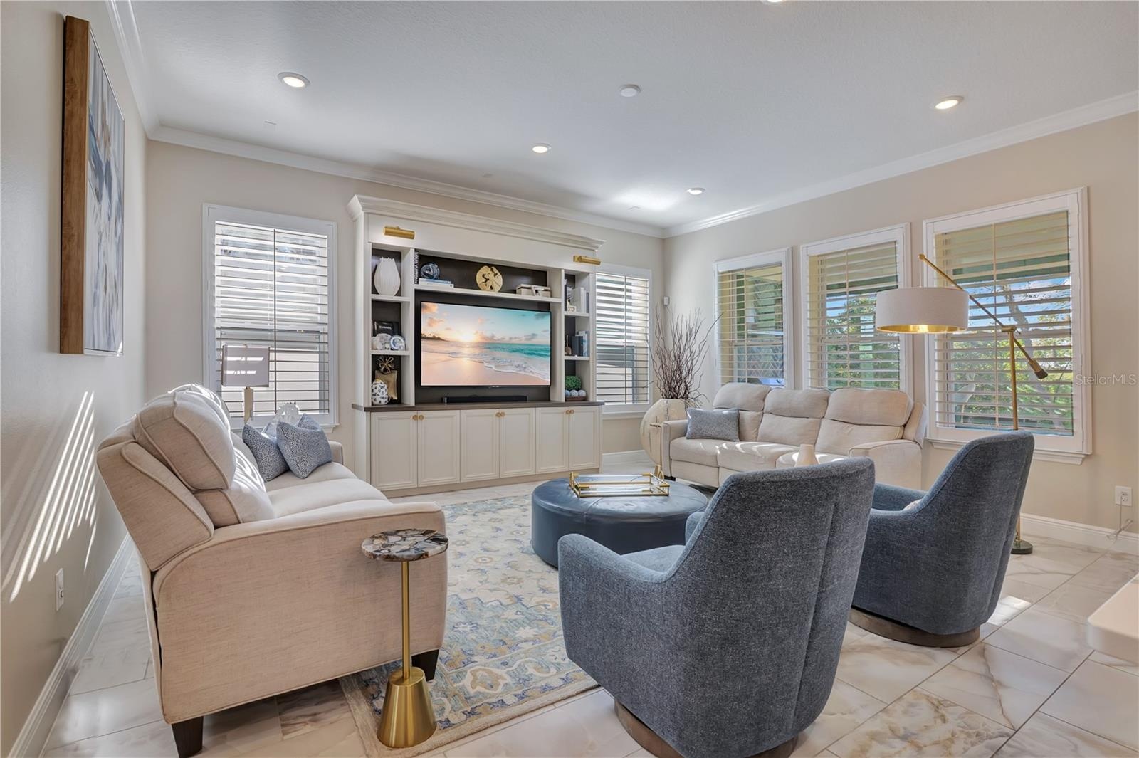 Bright family room with multiple windows and an open layout offers comfortable space for relaxing and entertaining.