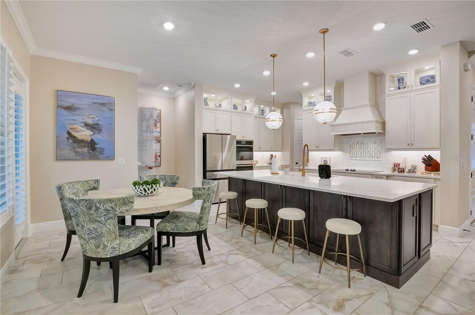 Spacious kitchen and breakfast area featuring upgraded tile flooring, crown molding and recessed lighting.