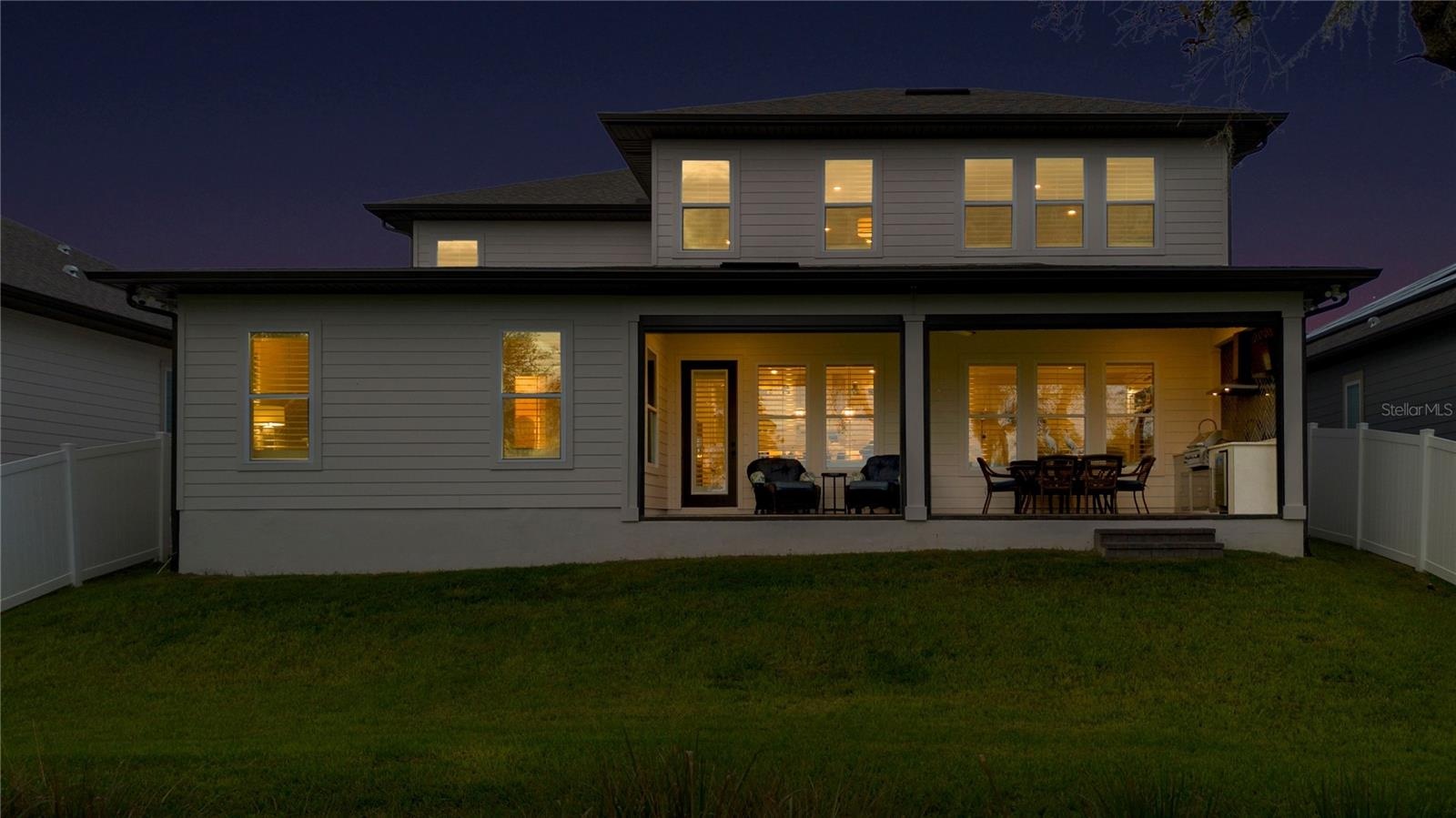 Rear twilight view featuring the covered lanai and inviting outdoor living areas.