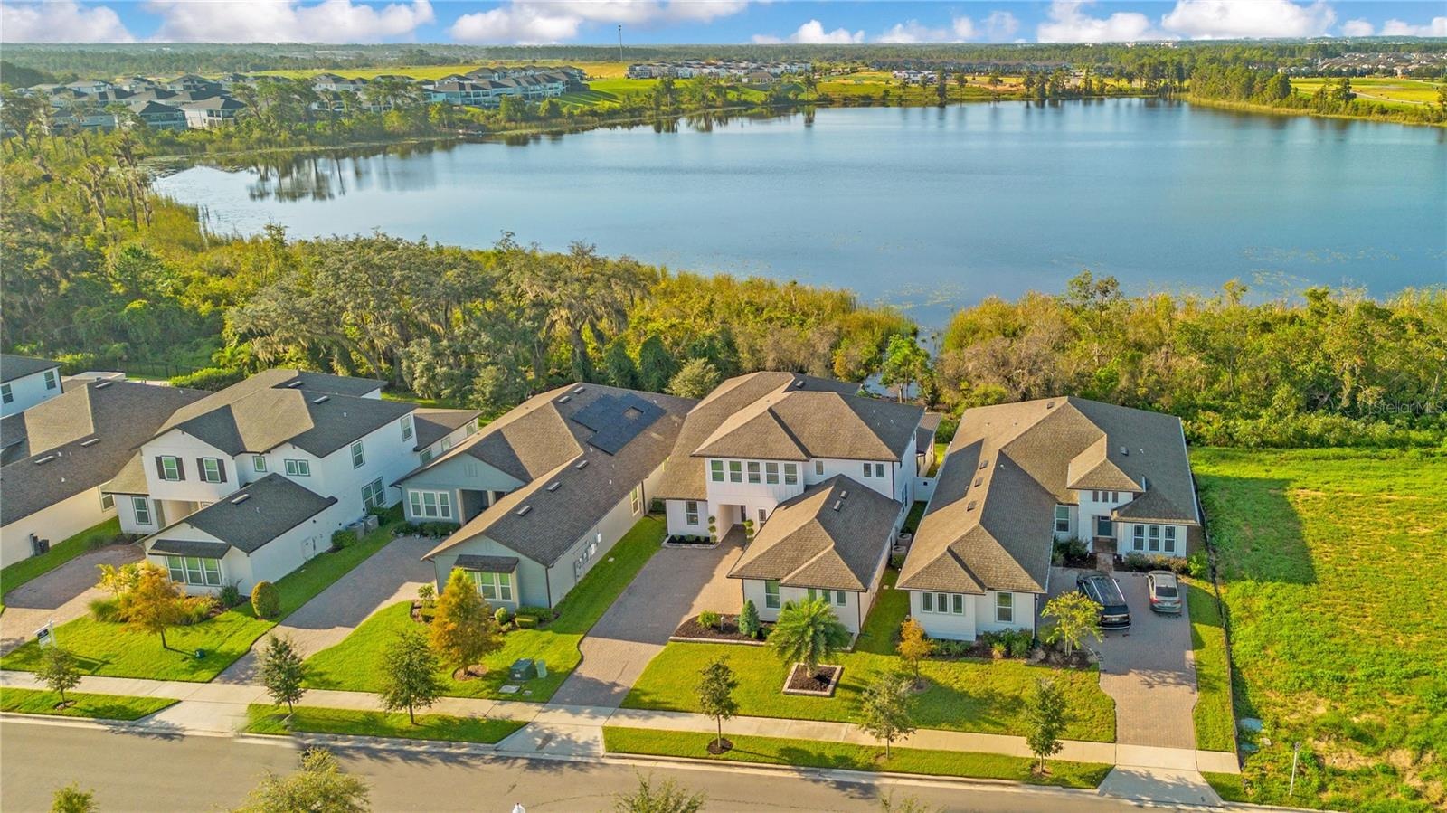 Aerial view showcasing the home’s scenic setting with the lake behind it.