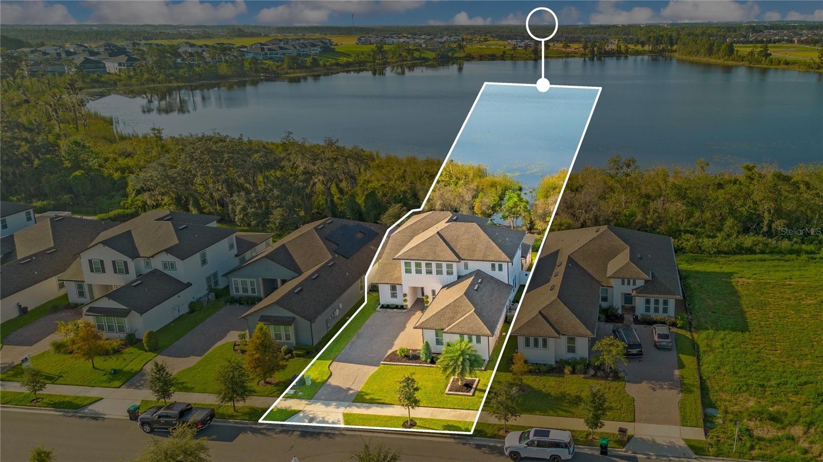Aerial view highlights the home’s setting beside the lake. Outline is approximate and for illustration only.