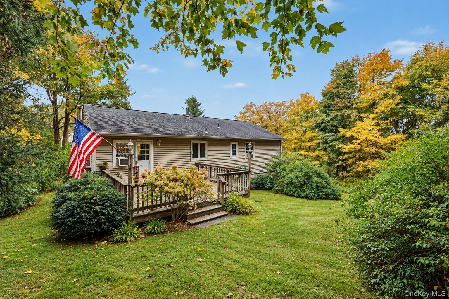 Back of home with attached deck and private yard