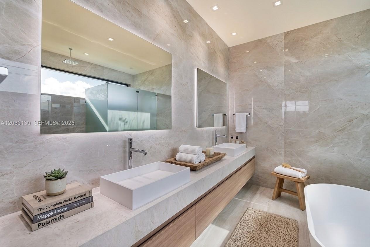 Primary Bathroom. Disclaimer: Several photographs presented in this listing contain digitally added furniture, artwork, and decor. These virtually sta