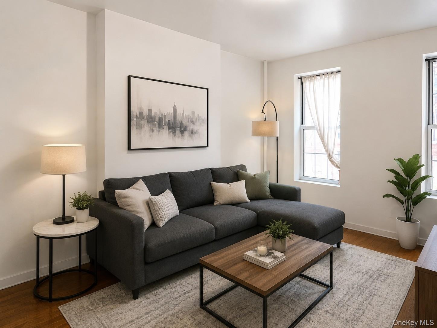 Living area with abundant natural light, featuring wood-finish flooring and crisp white walls (virtually staged)