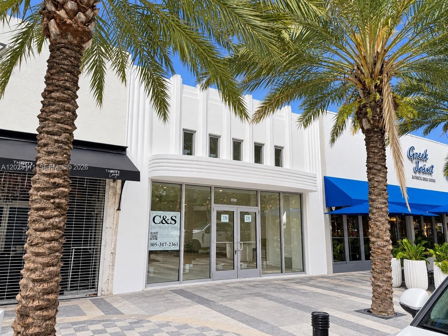 Art Deco-inspired facade featuring clean, vertical masonry detailing, extensive floor-to-ceiling glass storefront, and double-glass entry doors