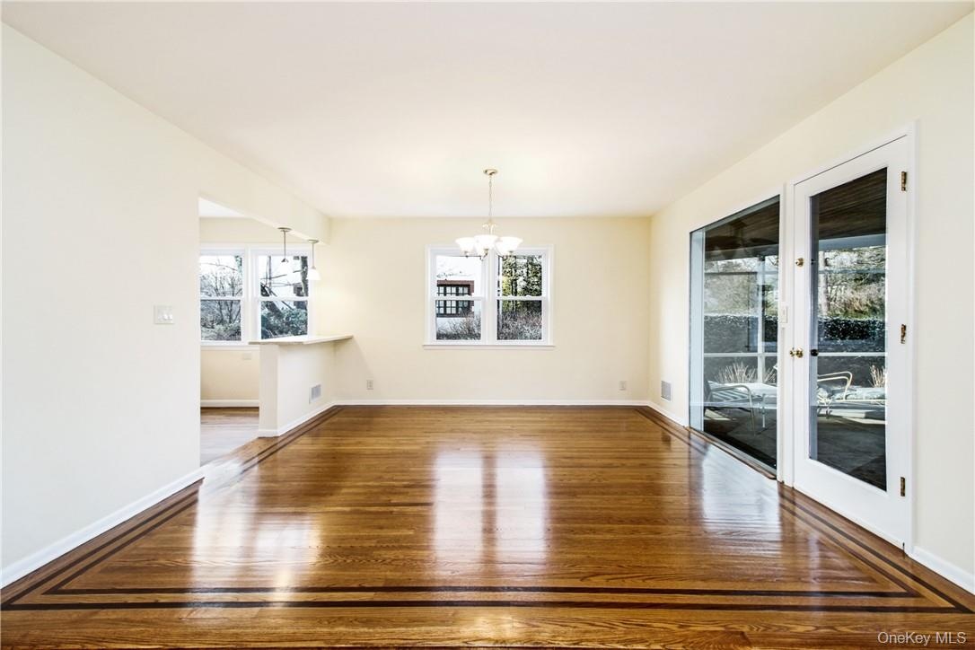 Spacious dining area with detailed oak. Photos taken when house was empty prior to occupancy. floors, access to kitchen and covered screened porch