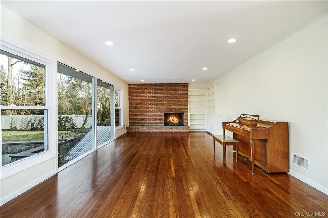 View of great room with large windows looking over yard and fireplace. Photos taken when house was empty prior to occupancy.