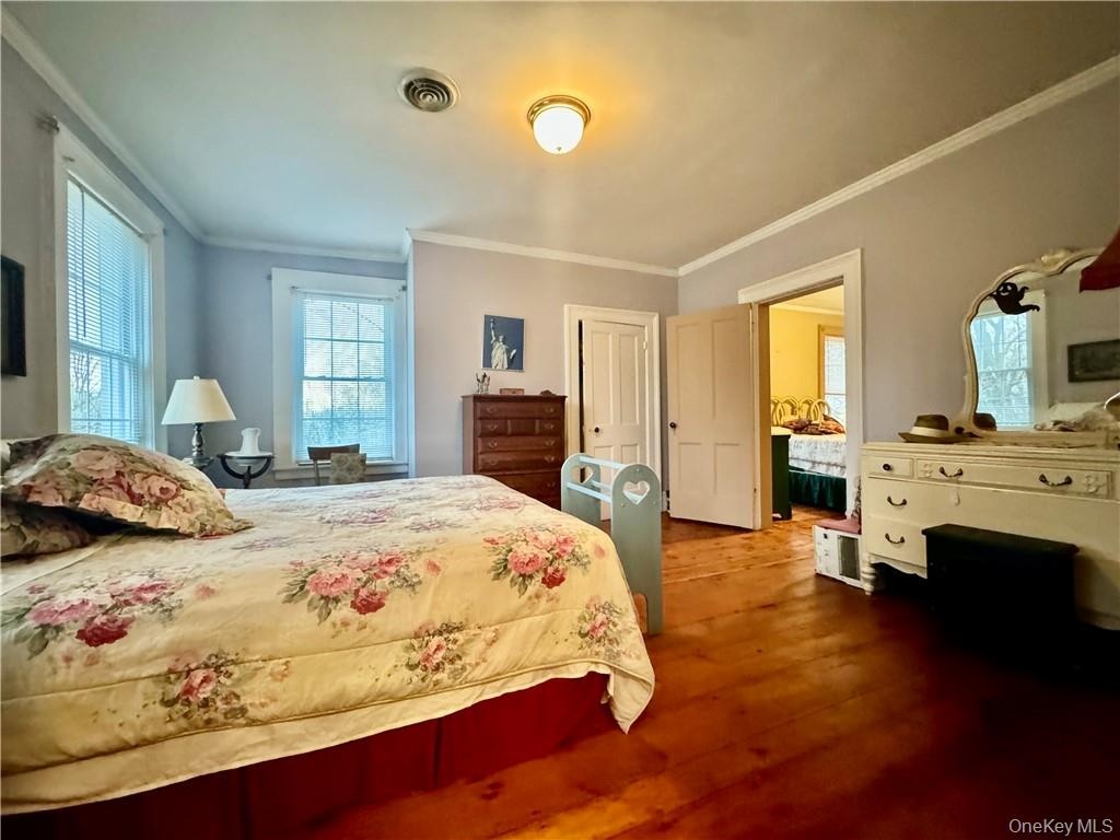 Bedroom with crown molding and hardwood / wood-style floors