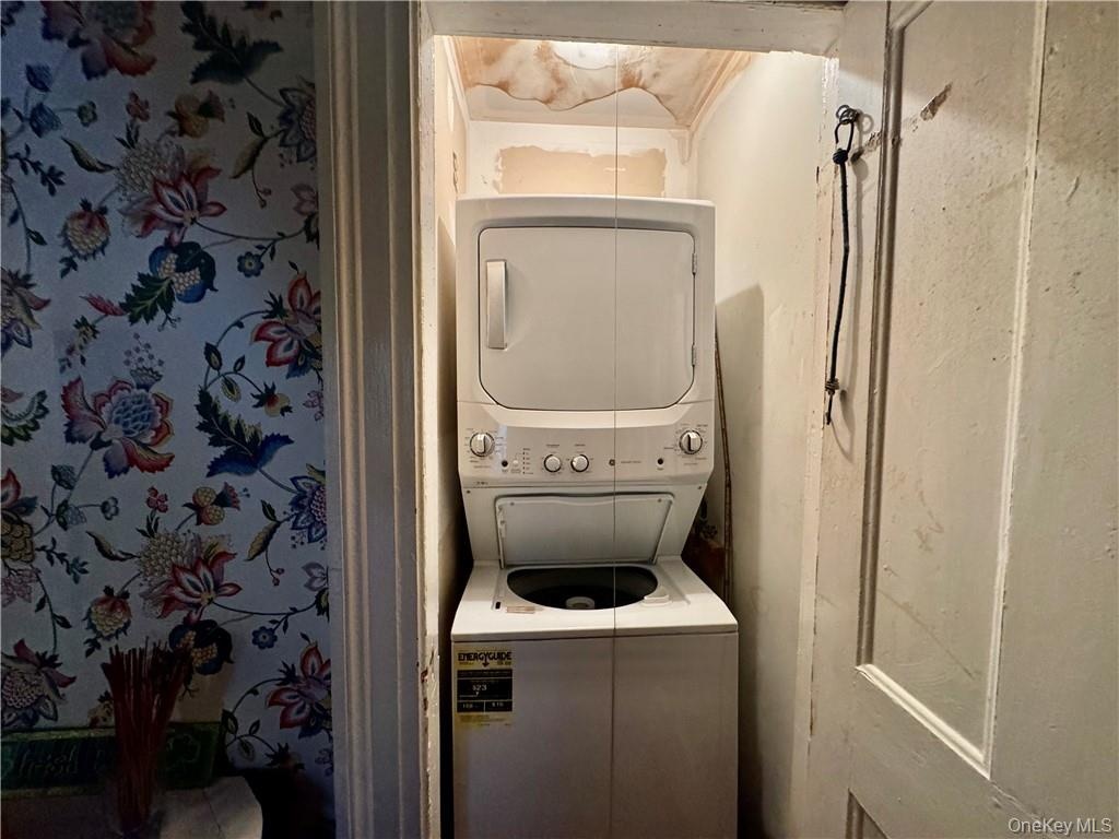 Laundry room with stacked washer and clothes dryer