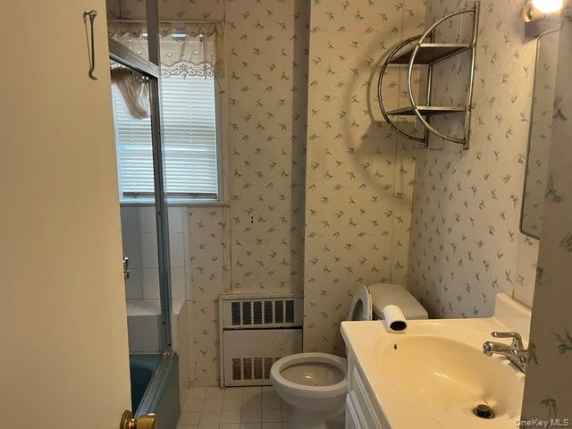 Full bath featuring wallpapered walls, vanity, light tile patterned flooring, and shower / washtub combination