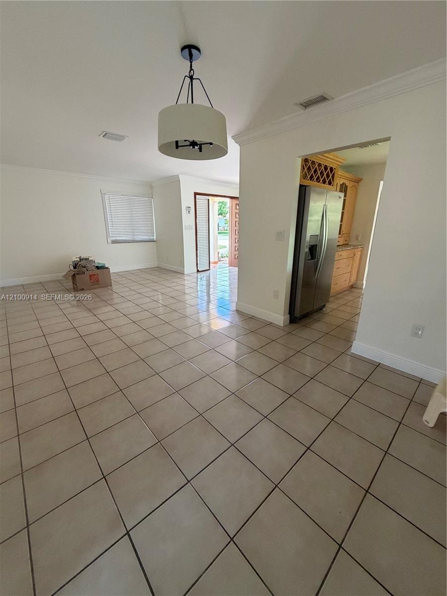Ceramic tile flooring throughout the area, drum-style pendant lighting, and crown molding