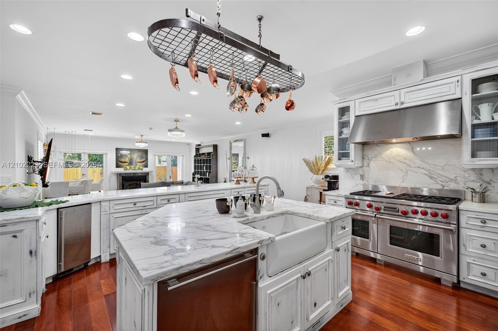 A chef’s kitchen with personality and character featuring distinctive, distressed, finish cabinetry, Premium, Wolf, Appliances, and beautiful marble s