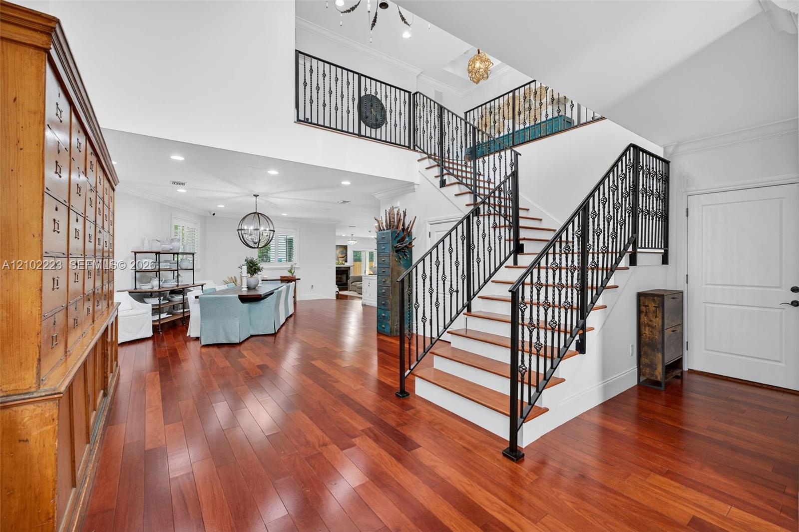 A striking architectural staircase with decorative rod, iron railings and warm wood, treads adds character and sophistication to the grand entry. Rich