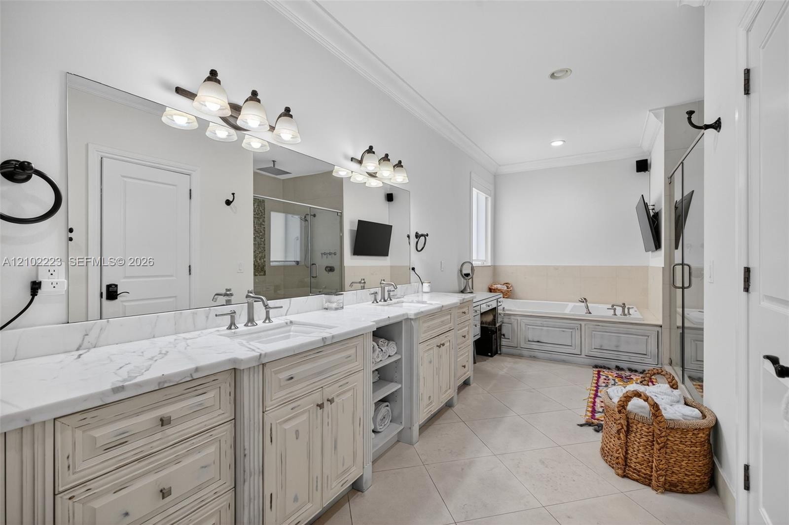A generously sized primary bath, featuring an expansive, dual sync, vanity, abundant, cabinetry, and counter space, a relaxing, soaking tub and a sepa