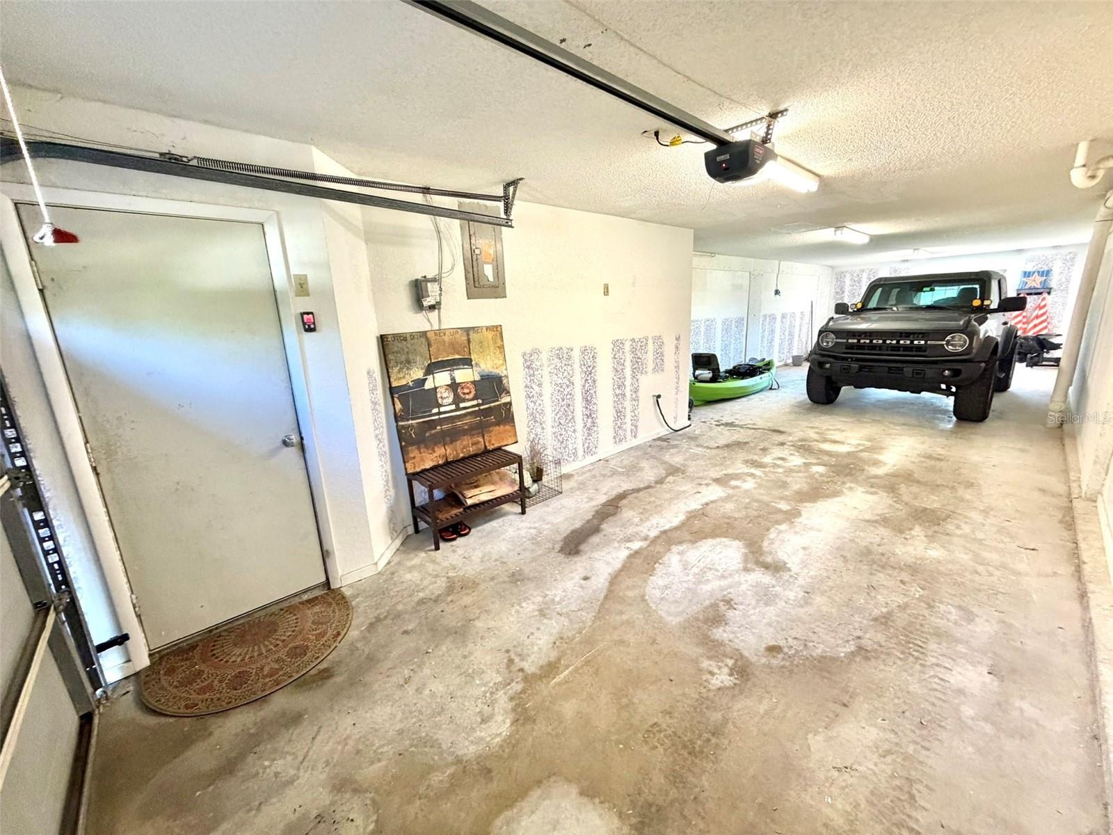 Tandem THREE CAR Garage with access to the private patio and additional storage space.